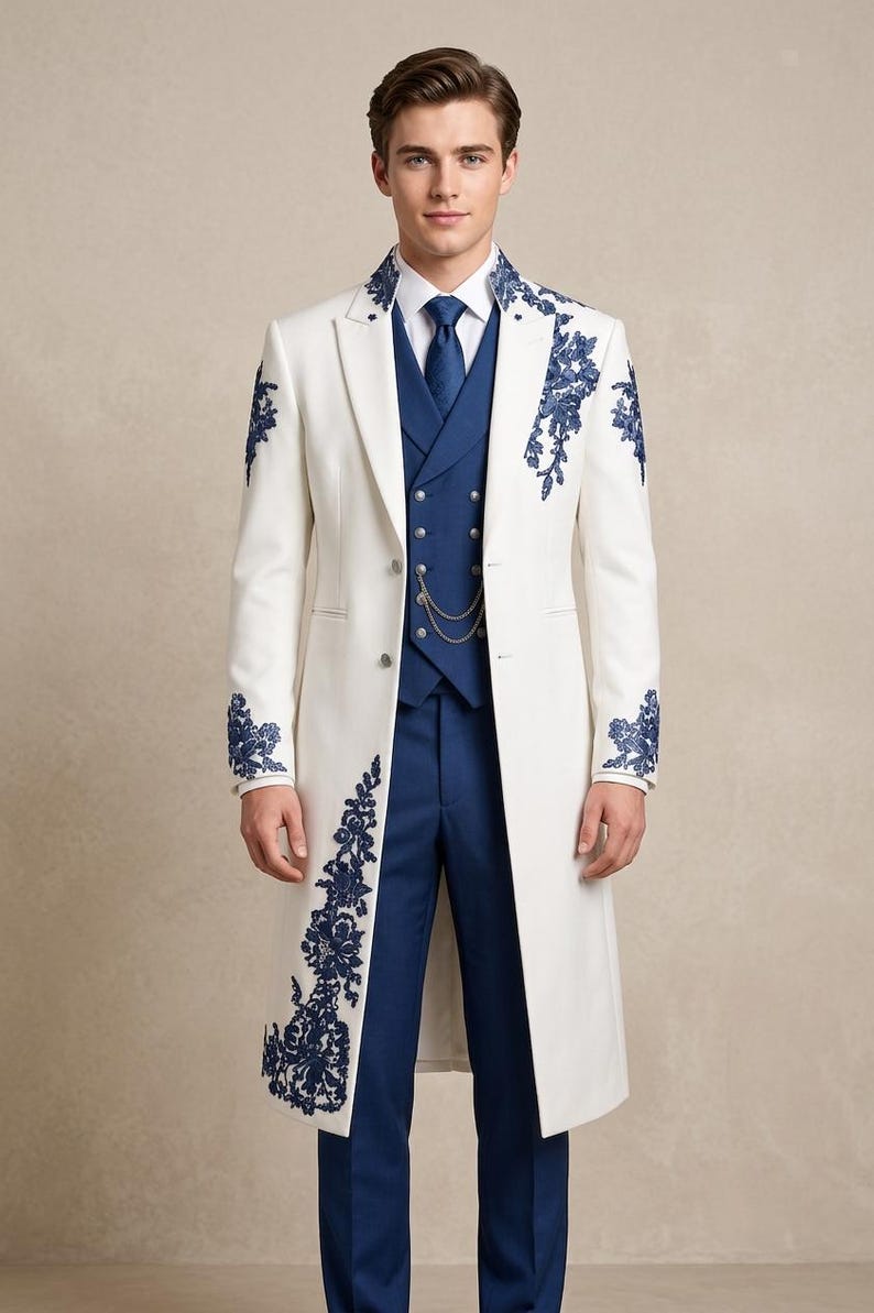 May include: A white long coat featuring dark blue floral embroidery on the lapels, shoulders, and lower front. The coat is worn over a dark blue vest with silver buttons and a chain, a white collared shirt, a dark blue tie, and blue trousers.