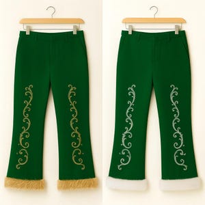 May include: Two pairs of dark green trousers hanging on wooden hangers. Each pair features vertical gold or silver filigree embroidery on the front legs and a thick, textured faux fur trim along the bottom hem of the pant legs.