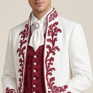 May include: A white long-sleeved jacket featuring dark red floral embroidery along the lapels and cuffs, worn over a dark red patterned vest with five round buttons. A white cravat with a central decorative pin is worn at the neck.