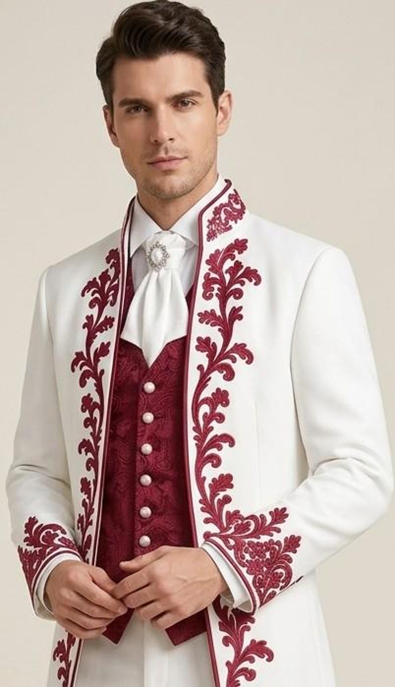 May include: A white long-sleeved jacket featuring dark red floral embroidery along the lapels and cuffs, worn over a dark red patterned vest with five round buttons. A white cravat with a central decorative pin is worn at the neck.