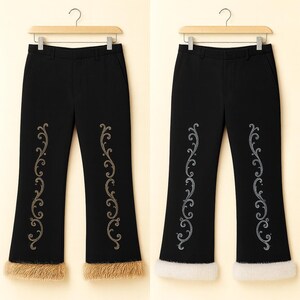 Pu&ograve; includere: Due paia di pantaloni neri appesi a grucce di legno. Ogni paio presenta un motivo ricamato a filigrana verticale dorato o argentato sulle gambe anteriori e un bordo spesso in pelliccia sintetica testurizzata sul fondo dei pantaloni.