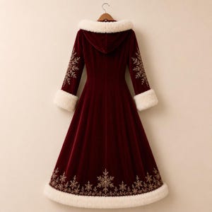 May include: A long-sleeved, floor-length deep red velvet coat featuring a hood trimmed with white faux fur. The cuffs and hem are also lined with white faux fur. Gold-colored snowflake embroidery patterns decorate the sleeves and the lower hem.