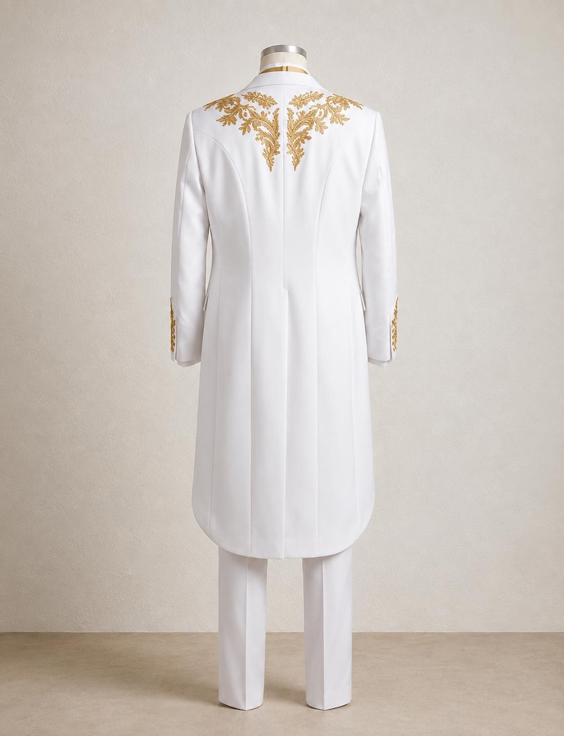May include: A white long-length coat and matching trousers. The coat features gold embroidery across the upper back and shoulders, with additional gold embroidery on the sleeve cuffs. The garment is displayed on a mannequin from the rear view.