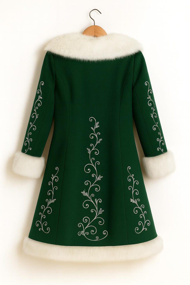 May include: A dark green coat featuring a white faux fur collar, white faux fur sleeve cuffs, and a white faux fur hem. The coat is decorated with silver-colored embroidered floral vine patterns running down the center and along the sleeves.