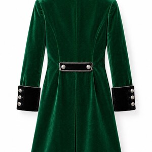 May include: A long-sleeved emerald green velvet coat featuring a black velvet collar with silver trim, black velvet cuffs with three silver buttons each, and a horizontal black velvet back tab detail adorned with two silver buttons.