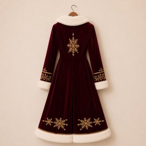 Pu&ograve; includere: Un cappotto lungo in velluto bordeaux scuro con colletto e orlo in pelliccia sintetica bianca. Il retro &egrave; decorato con motivi a fiocco di neve ricamati in oro e dettagli in filigrana intricati lungo i polsini delle maniche.