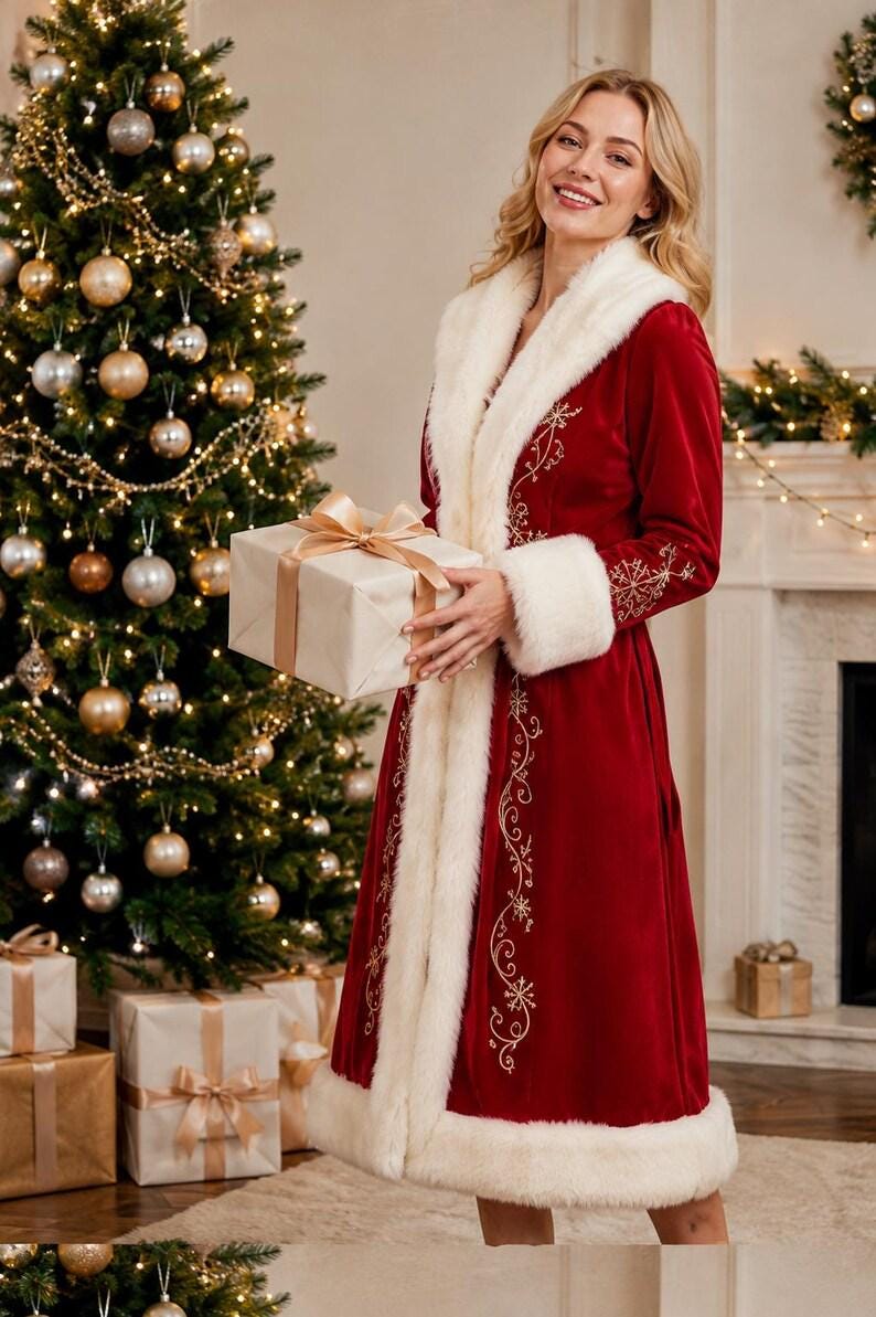 May include: A long-sleeved, deep red velvet coat featuring a thick white faux fur trim along the collar, cuffs, and hem. The coat is decorated with intricate gold embroidered snowflake patterns and swirling vine designs along the front panels.