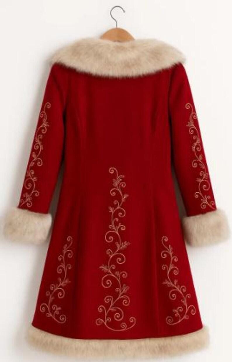 May include: A long-sleeved red coat featuring a beige faux fur collar, cuffs, and hem. The coat is decorated with gold-colored swirling vine embroidery patterns along the sleeves and down the center and sides of the back panel.