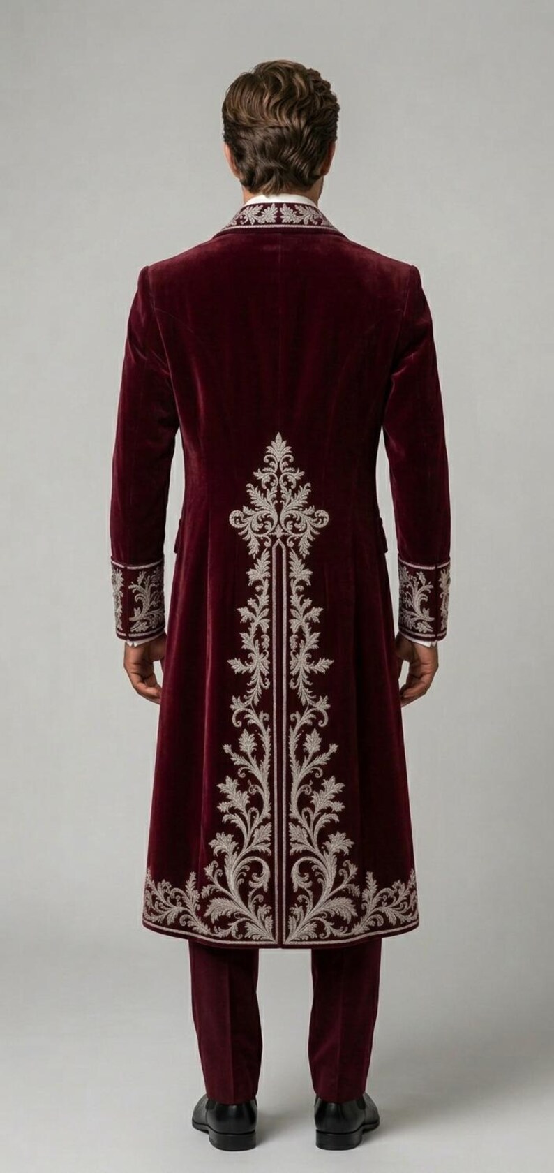 Pu&ograve; includere: Un cappotto lungo in velluto bordeaux intenso con intricati ricami color argento sul retro, sui polsini e sul colletto. Il cappotto presenta una vestibilit&agrave; strutturata, maniche lunghe e un motivo floreale verticale centrale sulla schiena.