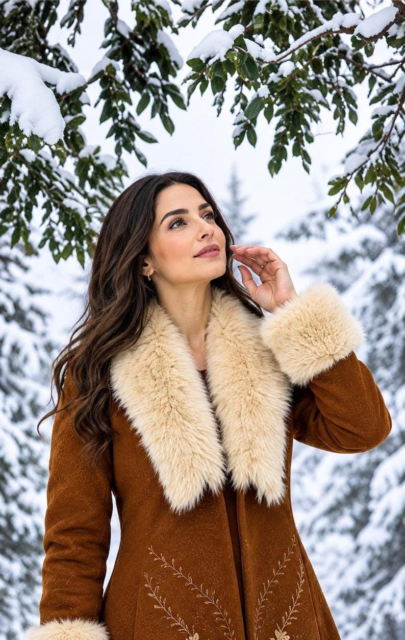 May include: A brown coat featuring a wide, cream-colored faux fur collar and matching faux fur cuffs on the sleeves. The coat is decorated with delicate, light-colored embroidered vine patterns along the front panels, creating a detailed texture.