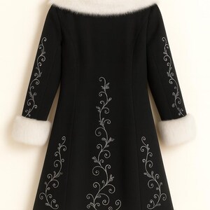 May include: A black coat featuring a white faux fur collar, white faux fur sleeve cuffs, and a white faux fur hem. The coat is decorated with silver embroidered floral vine patterns running down the center and along each sleeve.