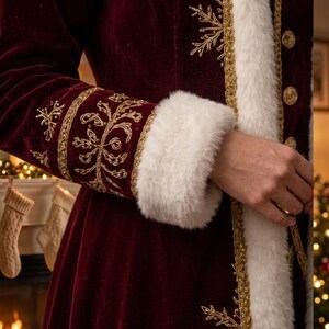 Pu&ograve; includere: Un cappotto in velluto bordeaux scuro con bordo in pelliccia sintetica bianca lungo l'apertura frontale e i polsini. Il cappotto &egrave; decorato con intricati ricami metallici dorati a forma di fiocchi di neve e volute, con bottoni dorati.