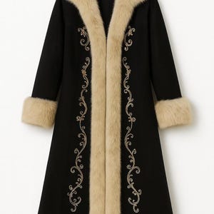 May include: A long black coat featuring a thick beige faux fur trim along the collar, cuffs, and hem. The front of the coat is decorated with intricate gold embroidery in a swirling vine pattern that runs vertically along the opening.