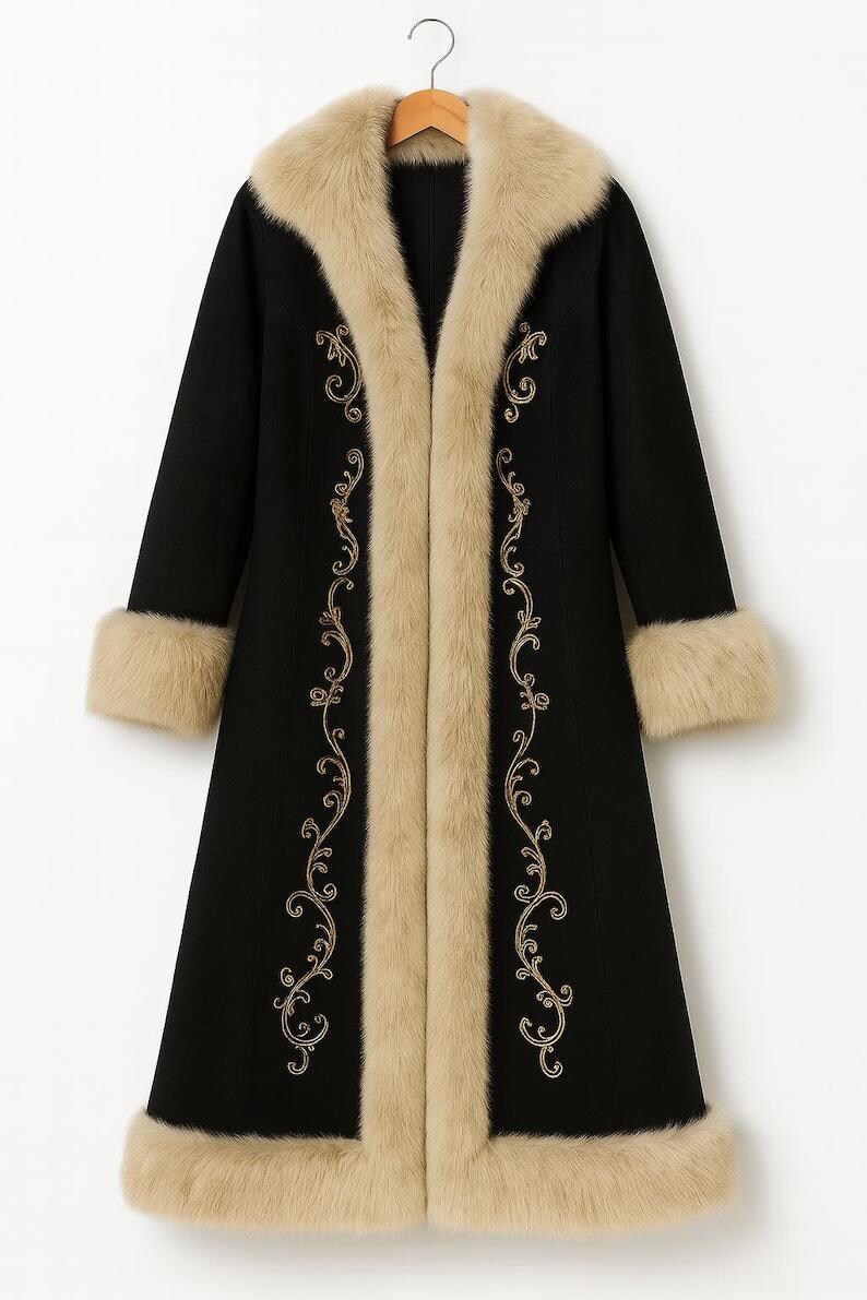 May include: A long black coat featuring a thick beige faux fur trim along the collar, cuffs, and hem. The front of the coat is decorated with intricate gold embroidery in a swirling vine pattern that runs vertically along the opening.
