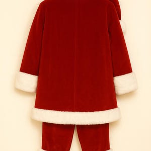 May include: A red velvet jacket and matching trousers set featuring white faux fur trim on the collar, sleeve cuffs, and hem. The jacket includes a long-sleeved design, and the set is accompanied by a matching red velvet hat with white fur trim.