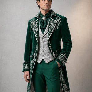 Puede incluir: Una levita de terciopelo verde oscuro con bordados florales plateados en las solapas y pu&ntilde;os, combinada con un chaleco gris claro estampado, pantalones verdes a juego y un corbat&oacute;n verde oscuro sujeto con un broche plateado en el cuello.