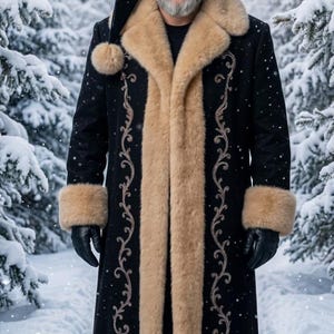 May include: A long black coat with tan faux fur trim on the collar, cuffs, and hem, featuring intricate silver embroidery along the front panels. The coat is paired with a matching black hat with a tan fur band and a dangling pom-pom.