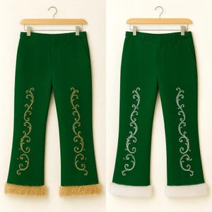 Pu&ograve; includere: Due paia di pantaloni verde scuro appesi a grucce di legno. Ogni paio presenta un ricamo dorato a volute sulla parte anteriore delle gambe e un bordo spesso in pelliccia sintetica sul fondo dei pantaloni.