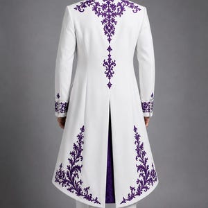 May include: A long white coat featuring intricate purple embroidery along the collar, back, and hemline. The garment has long sleeves with purple embroidered cuffs, a high collar, and a center back vent revealing a deep purple inner lining.