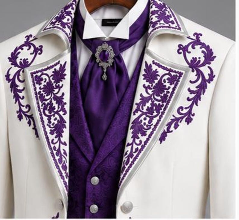 May include: A white blazer featuring purple floral embroidery on the lapels, worn over a purple vest with a subtle pattern and a white collared shirt. A purple cravat is secured with an ornate silver brooch featuring a central purple stone.