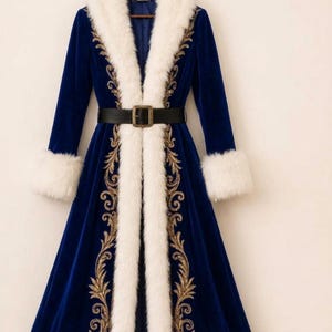 May include: A long, royal blue velvet coat featuring a thick white faux fur trim along the collar, cuffs, and hem. The coat is adorned with intricate gold embroidery along the front panels and is cinched at the waist with a black belt.