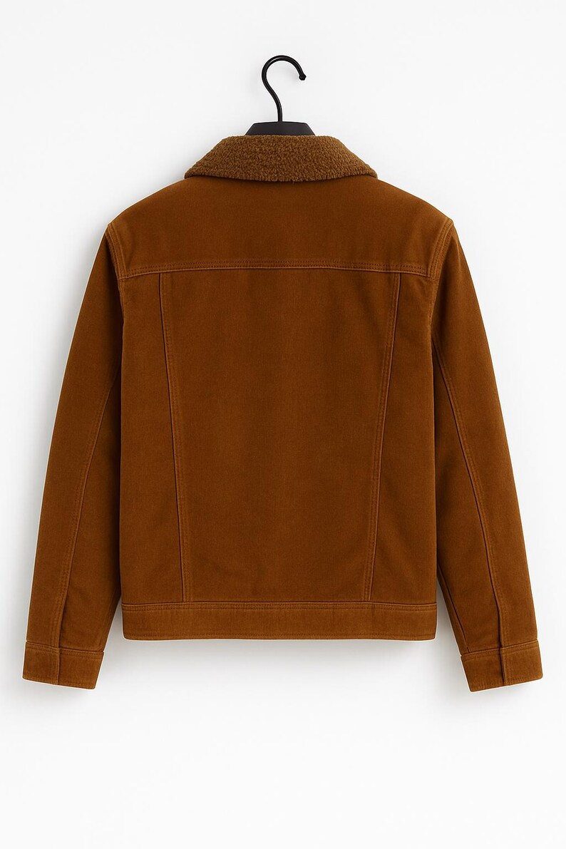 May include: A brown corduroy jacket with a contrasting faux shearling collar. The jacket features a classic design with a button closure, two chest pockets, and a straight hem. The jacket is hanging on a black hanger.