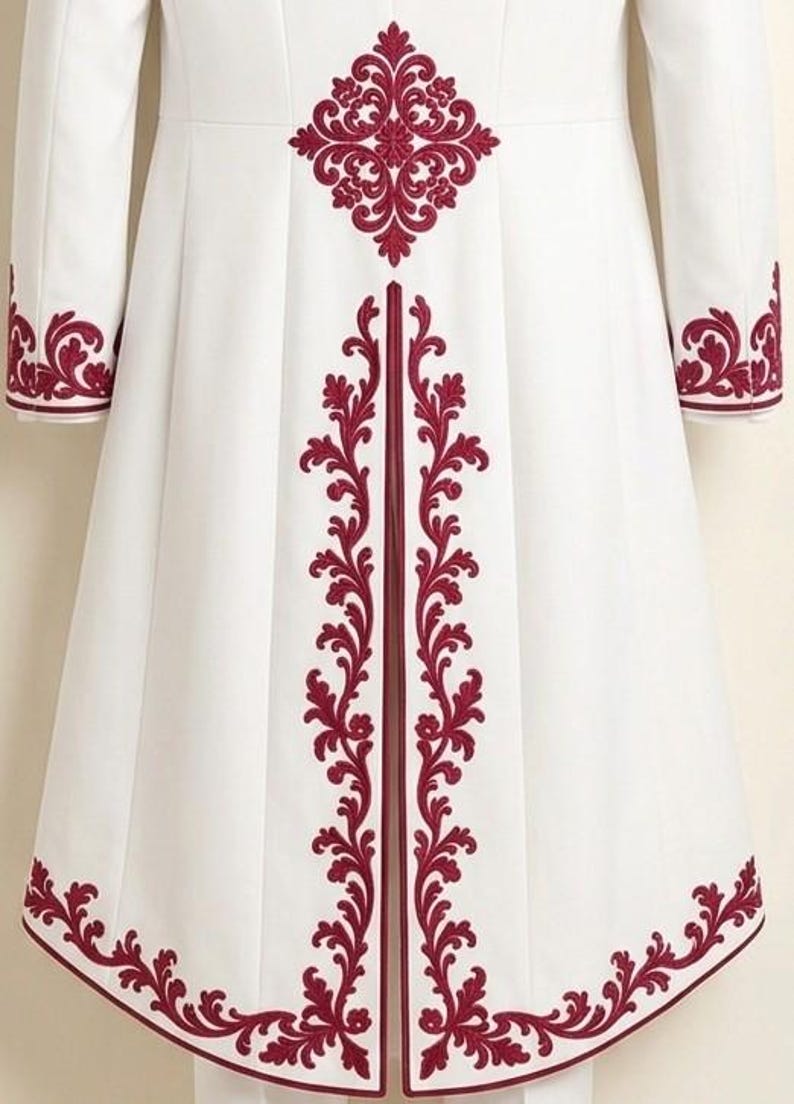 May include: A white long coat featuring deep red embroidery in a symmetrical floral and scroll pattern. The design is placed along the hem, the cuffs, and vertically down the center back, with a prominent medallion motif at the upper back.