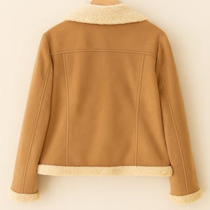 May include: A tan jacket with a cream-colored shearling collar and trim. The jacket is hanging on a wooden hanger against a light beige background. The back of the jacket is visible, showing seams and a classic design.