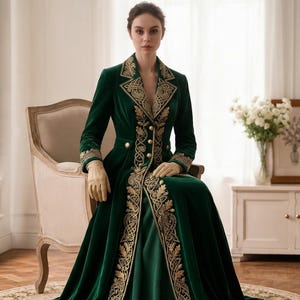 May include: A floor-length dark green velvet coat featuring long sleeves, a notched lapel, and gold embroidery along the front opening and cuffs. The garment includes a fitted waist with gold buttons and a full, flowing skirt that reaches the floor.
