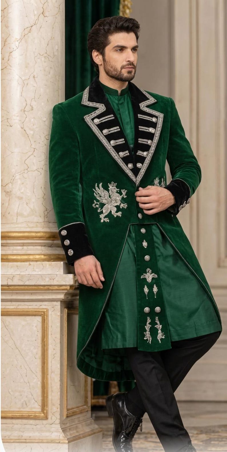 May include: A dark green velvet long coat featuring black velvet lapels and cuffs with silver embroidery. The coat includes a silver griffin emblem on the chest, silver buttons, and a matching green tunic underneath with silver floral embroidery.