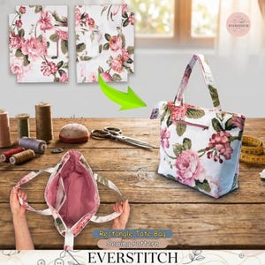 May include: White tote bag with a floral pattern of pink roses and green leaves. The bag has a zipper closure and a matching interior. The image also shows sewing supplies and the text "Rectangle Tote Bag Sewing Pattern EVERSTITCH".
