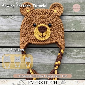Op de afbeelding: Een handgemaakte gehaakte babyberenmuts in bruin-, geel- en zwarttinten. De muts heeft berenoren, een berengezicht en gevlochten kwastjes. De tekst "Sewing Pattern Tutorial", "3 sizes" en "Handmade Crochet Baby Bear Hat" is inbegrepen.