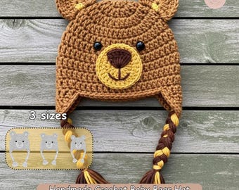 May include: A handmade crochet baby bear hat in shades of brown, yellow, and black. The hat features bear ears, a bear face, and braided tassels. The image includes the text "Sewing Pattern Tutorial", "3 sizes", and "Handmade Crochet Baby Bear Hat".