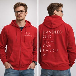 Könnte beinhalten: Ein roter Kapuzenpullover mit Reißverschluss und weißem Text auf der Vorder- und Rückseite. Auf der Vorderseite steht "I ♡ VIBECODING". Auf der Rückseite steht "HANDLED OLD TECH. CAN HANDLE AI.". Der Hoodie hat eine Kapuze und Taschen.