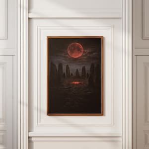 Può includere: Stampa incorniciata raffigurante un paesaggio cupo e drammatico. Una grande luna rossa domina il cielo sopra un cerchio di pietre scure e imponenti. Un bagliore infuocato emana dal centro della scena, creando un'atmosfera misteriosa.