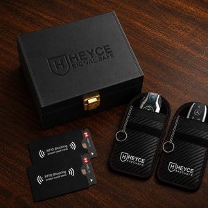 May include: A black rectangular storage box with the embossed text HEYCE SIGNAL SAFE, two black RFID blocking cards, and two black carbon fiber textured key pouches with the HEYCE keyGuard logo and attached metal key rings.