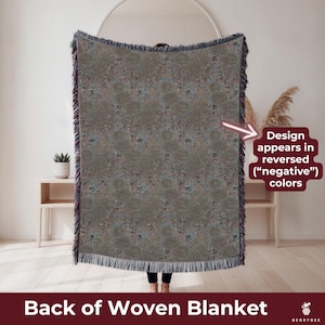 May include: A woven blanket with a muted color palette of gray, blue, and brown. The design appears in reversed colors. The blanket has a fringed edge and is labeled "Back of Woven Blanket."