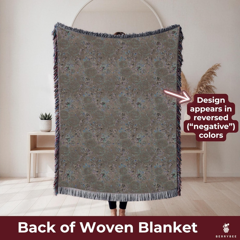 May include: A woven blanket with a muted color palette of gray, blue, and brown. The design appears in reversed colors. The blanket has a fringed edge and is labeled "Back of Woven Blanket."