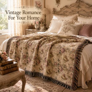 May include: A bed with a floral patterned throw blanket, pillows, and a decorative headboard. The throw blanket features a beige background with pink and purple roses. The text "Vintage Romance For Your Home" is displayed at the top of the image.