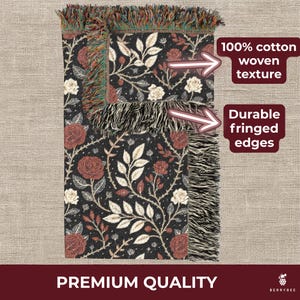 May include: A black woven throw blanket with a floral pattern of red roses and cream-colored leaves. The blanket has fringed edges and the text "100% cotton woven texture" and "Durable fringed edges". The words "Premium Quality" are also visible.