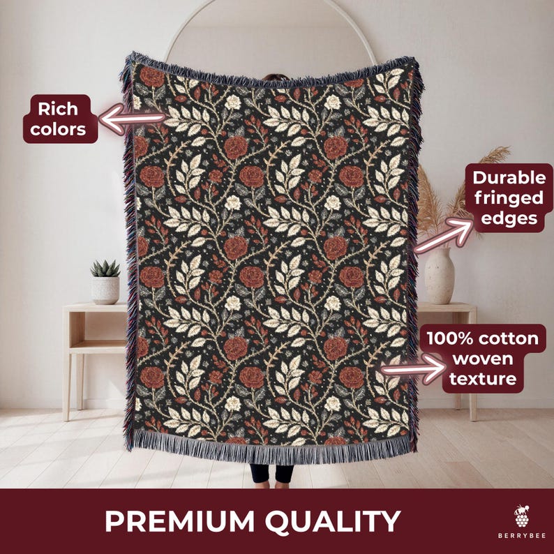 May include: A woven cotton throw blanket with a floral pattern of red roses and white leaves on a black background. The blanket has fringed edges and the words "Premium Quality" are at the bottom.