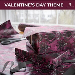 May include: Two wrapped gifts with a black and silver floral pattern on a magenta background. The gifts are on a table with wrapping paper, scissors, and a ribbon. The text "VALENTINE'S DAY THEME" is at the top.