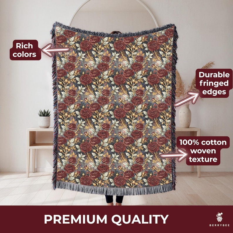 May include: Woven cotton throw blanket with a floral rose pattern in burgundy, gold, and green on a dark background. The blanket has fringed edges and the text "PREMIUM QUALITY".