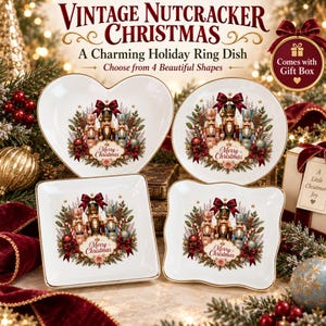 May include: Four white ceramic ring dishes in heart, round, square, and scalloped shapes. Each dish features a central illustration of three nutcrackers surrounded by greenery, red bows, and the text Merry Christmas in elegant script.