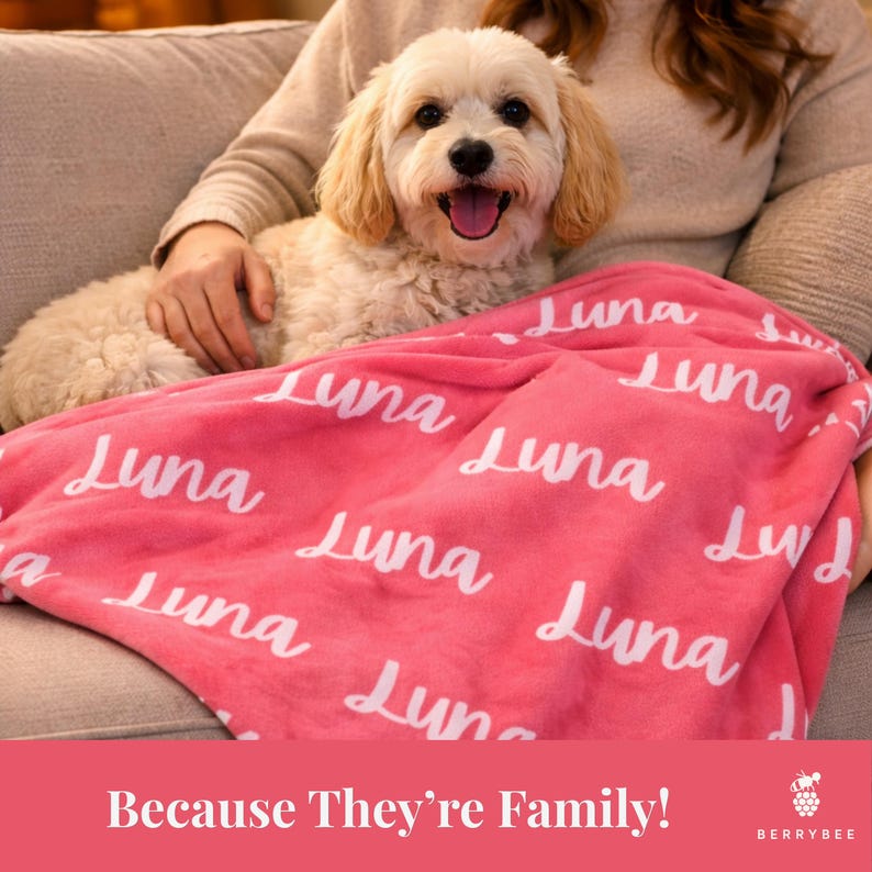 以下が含まれることがあります： 白い筆記体で「Luna」とプリントされたピンク色のブランケット。小さな薄い色の犬がブランケットの上にいます。「Because They're Family!」というテキストが下にあります。