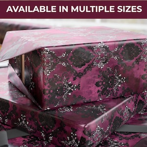 May include: Gift wrap with a damask pattern in shades of burgundy, black, and silver. The wrapping paper is layered, with the top layer partially open, revealing the box underneath. Text at the top reads "AVAILABLE IN MULTIPLE SIZES."