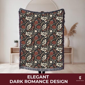 May include: A dark blanket with a floral pattern featuring red roses and white leaves on a black background. The blanket has a fringed edge and the text "ELEGANT DARK ROMANCE DESIGN" at the bottom.