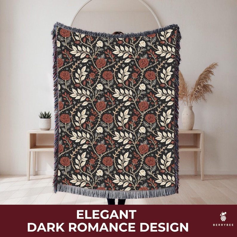 May include: A dark blanket with a floral pattern featuring red roses and white leaves on a black background. The blanket has a fringed edge and the text "ELEGANT DARK ROMANCE DESIGN" at the bottom.
