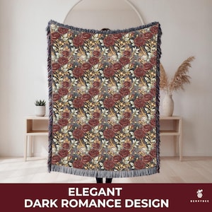 May include: A woven throw blanket with a dark floral pattern featuring burgundy roses and gold accents. The blanket has a dark blue background and a fringed edge. The text "ELEGANT DARK ROMANCE DESIGN" is at the bottom.