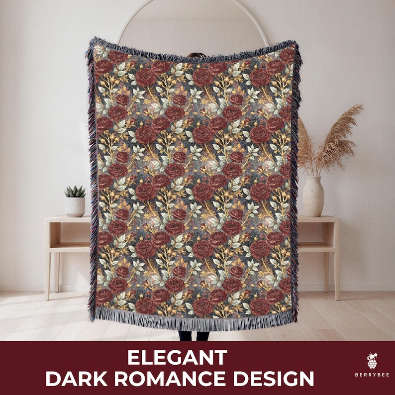 May include: A woven throw blanket with a dark floral pattern featuring burgundy roses and gold accents. The blanket has a dark blue background and a fringed edge. The text "ELEGANT DARK ROMANCE DESIGN" is at the bottom.
